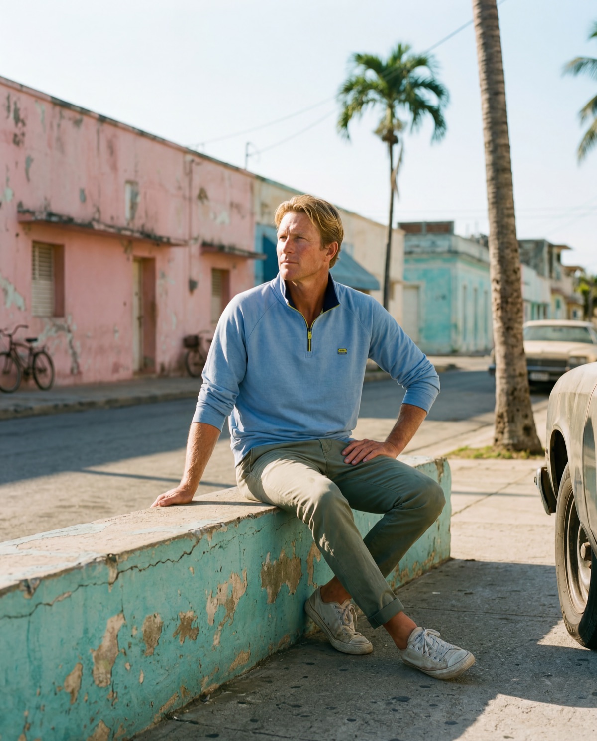 Man seated on curb in sweatshirt — candid street